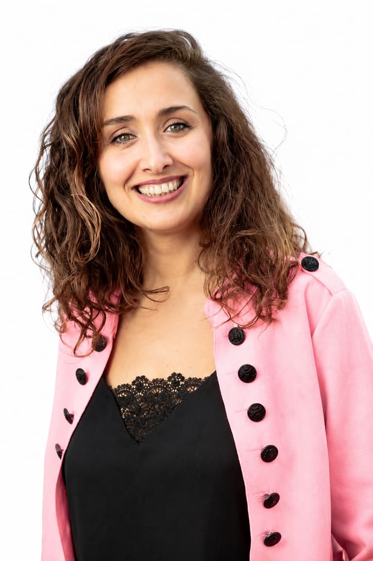 Mariam Djaroud souriante, en veste rose, sur fond blanc